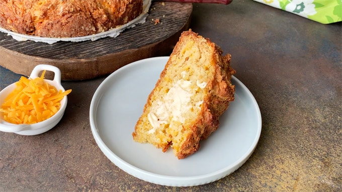 Big slice of Cheddar Soda Bread smeared with butter