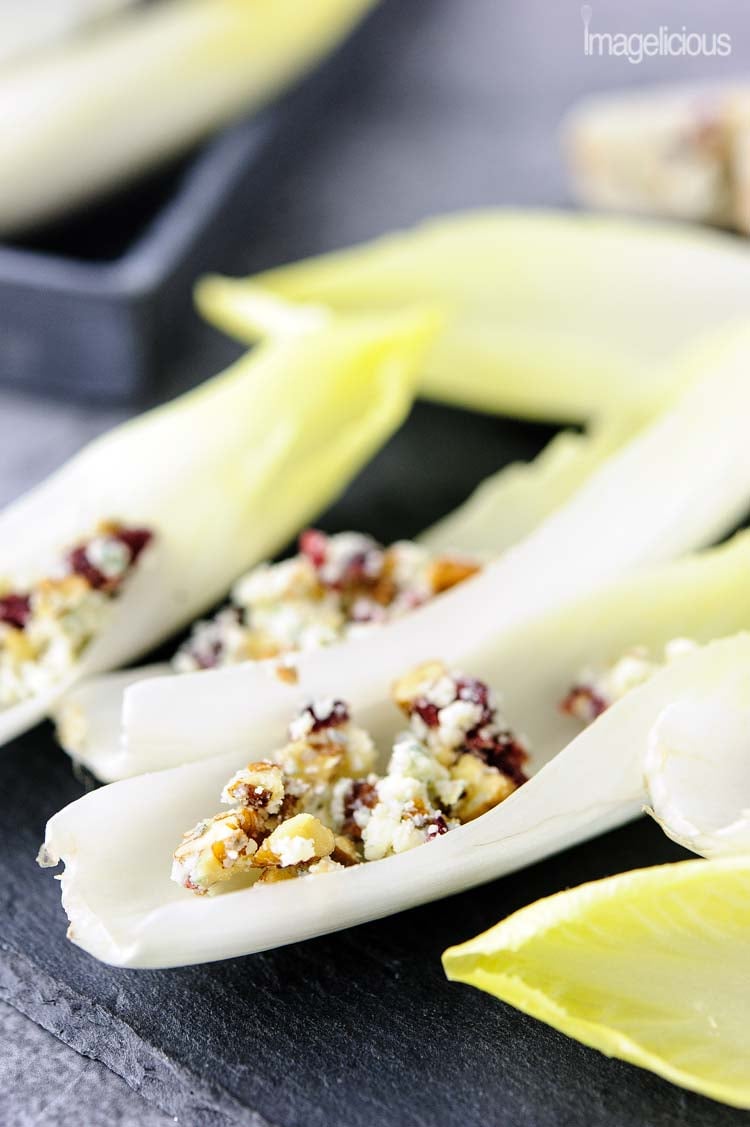 Closeup photo of endive appetizer boats with blue cheese, pecans, and cranberries
