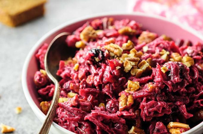 A bowl of beet salad with a few sprinklings of chopped pecans