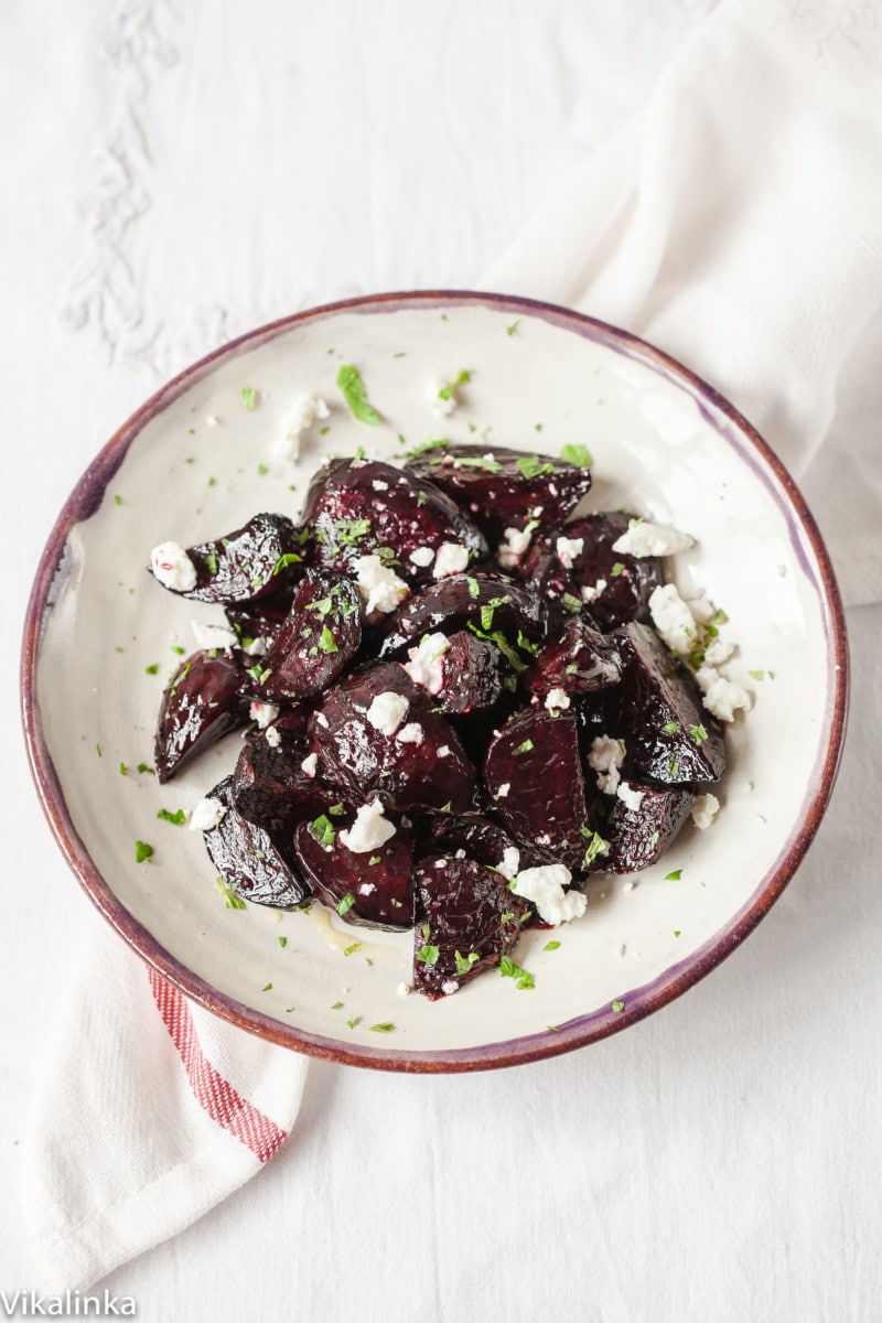 Top down view of a plate of roasted beets with crumbled goat cheese