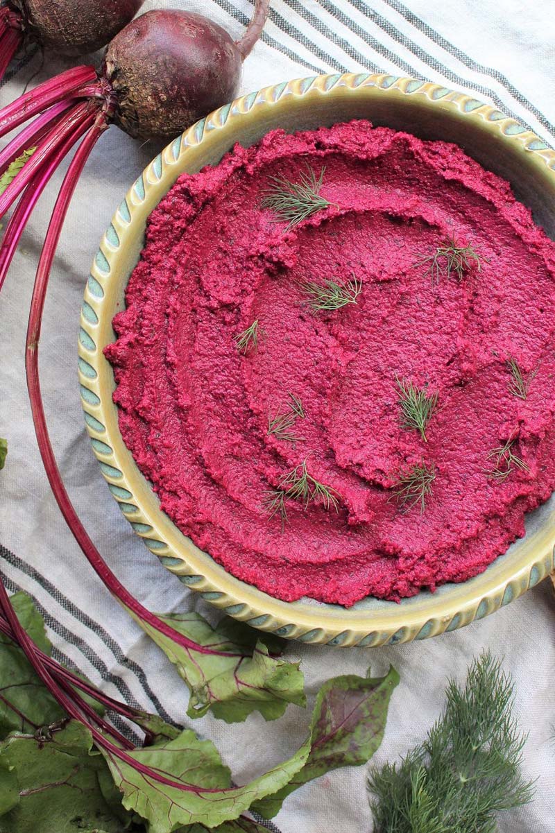 Top down view of a bowl filled with pink beet hummus