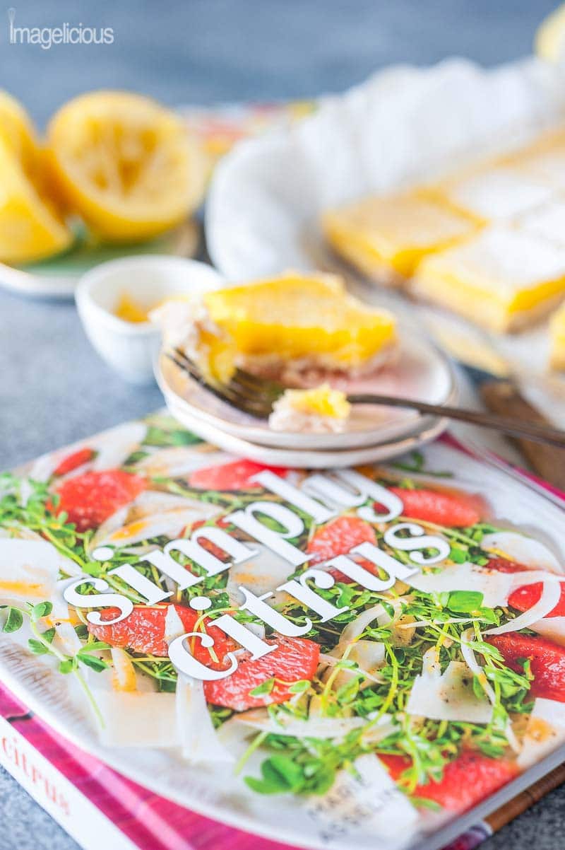 Simply Citrus cookbook with coconut lemon bars in the background.