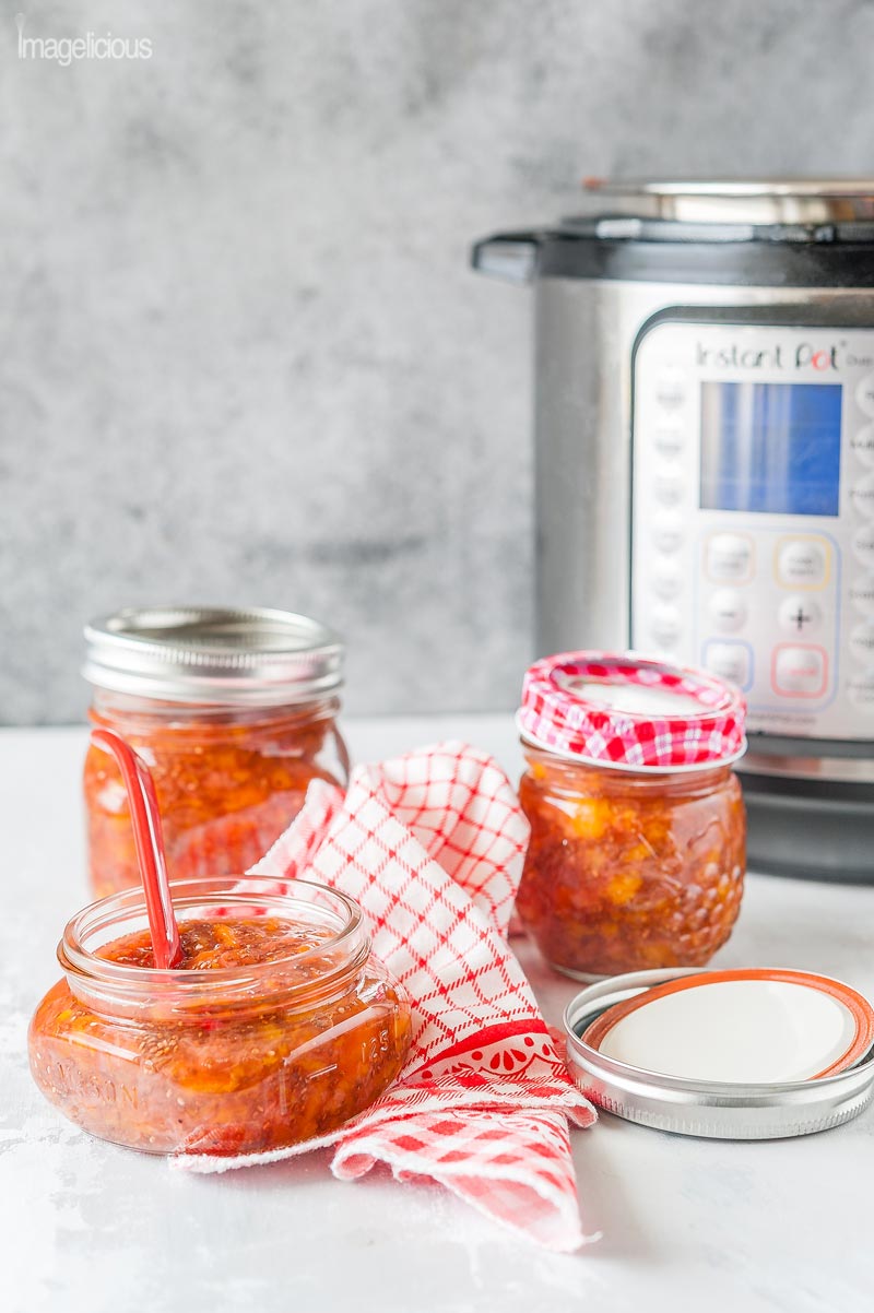 Three jars of Instant Pot Strawberry Chia Jam with an Instant Pot in the background