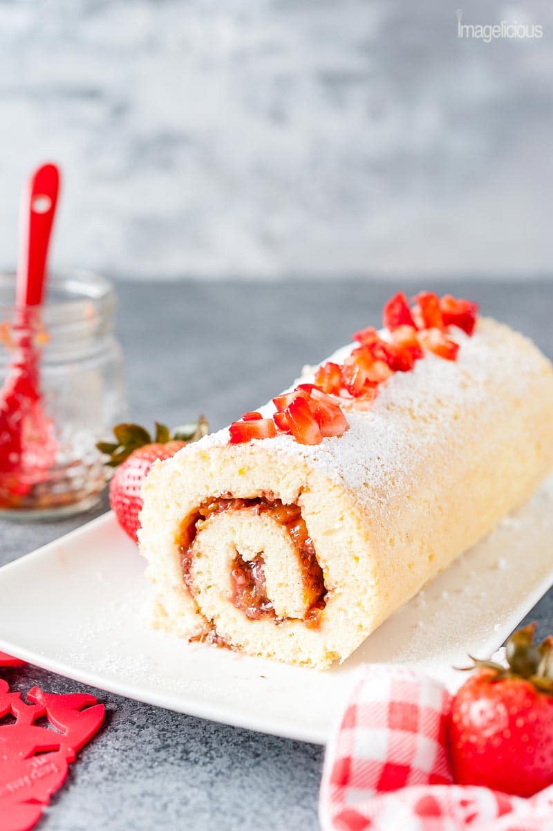 A plate with a 3-ingredient cake roll with strawberry jam