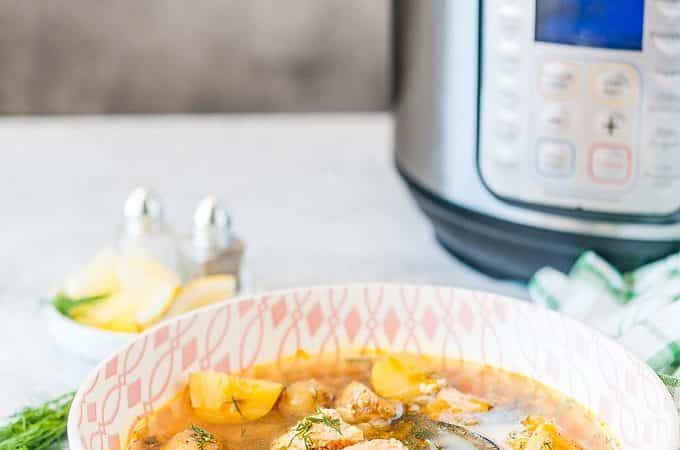 Side view photo of a bowl of beautiful Instant Pot Fish Soup with Instant Pot in the background