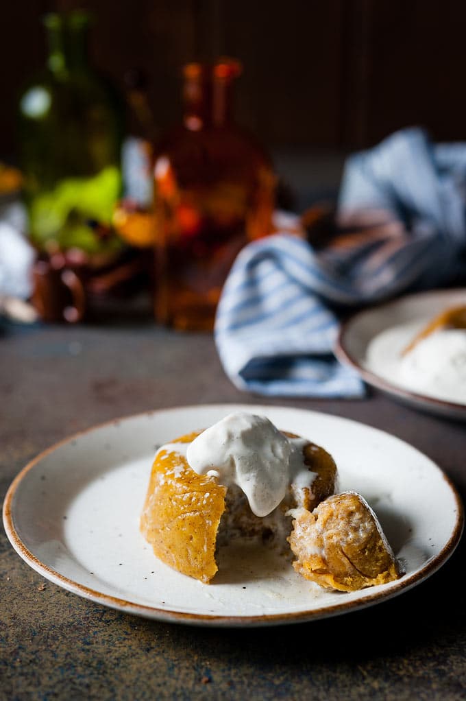 Instant Pot Pumpkin Pudding Cake on a plate with ice cream melting over it and a piece cut out of it