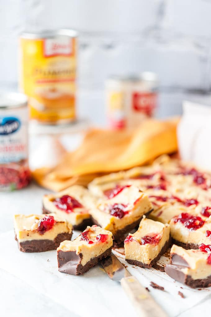 Photo of Pumpkin Cranberry Fudge cut up into serving pieces with a few cans in the background
