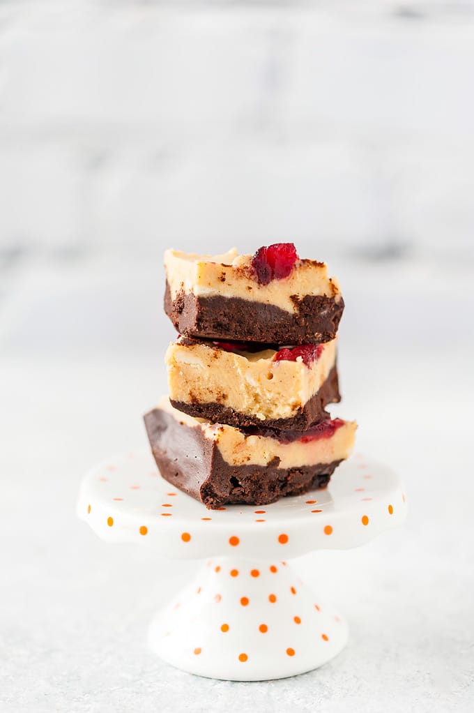 Three pieces of Pumpkin Cranberry Fudge are stacked on top of each other on a small pedestal
