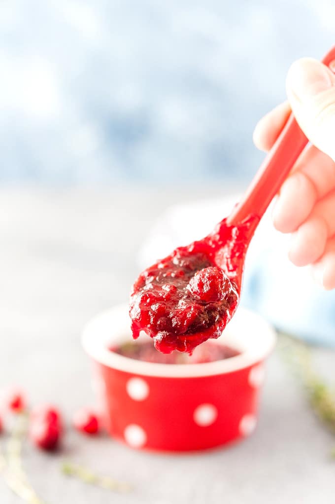 A hand holding a spoonful of Instant Pot Maple Cranberry Sauce