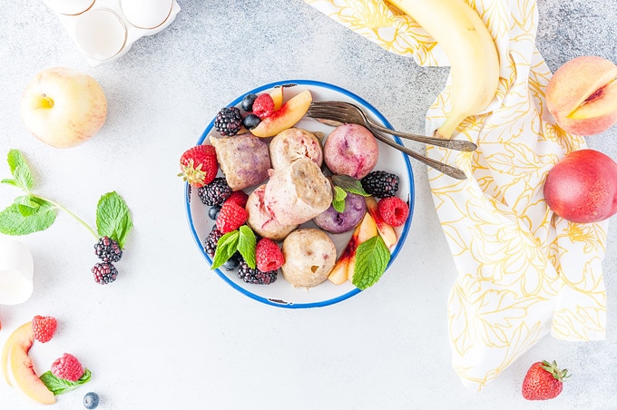 Horizontal photo of a plate full of Instant Pot Fruity Egg Bites and fruit around them