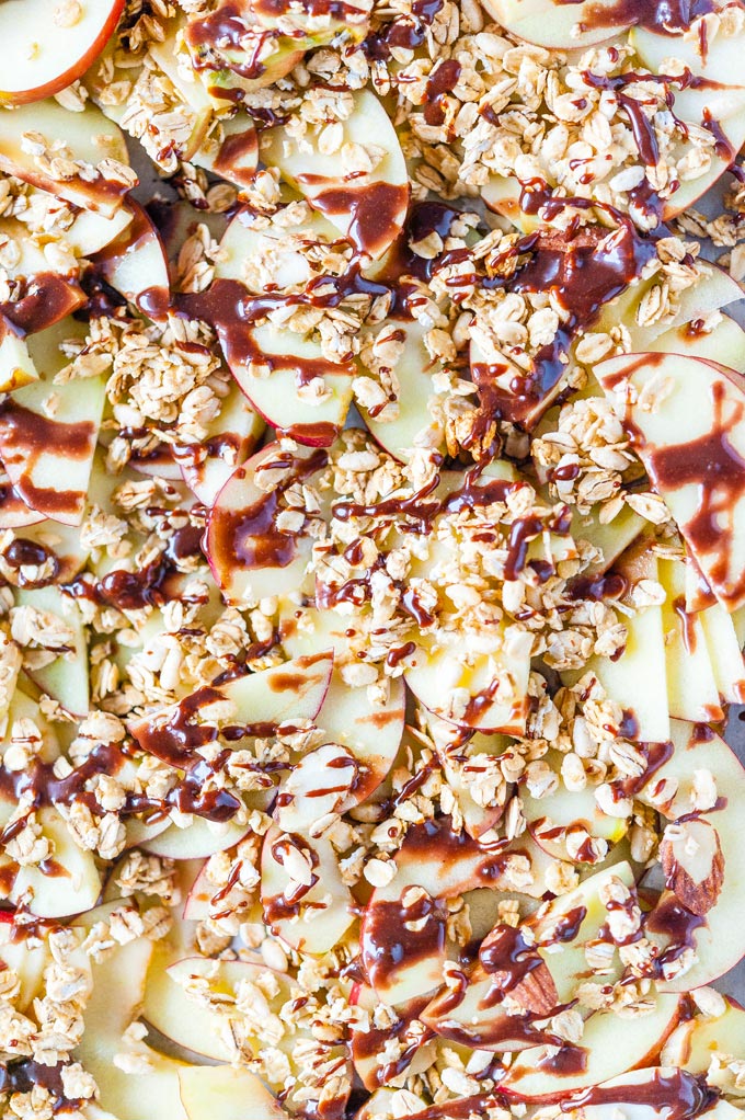 Macro photo of apples slices drizzled with caramel and granola