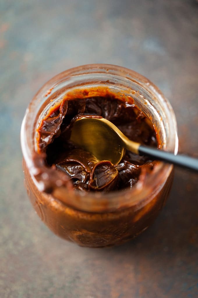 Photo of the inside of the jar of Instant Pot Chocolate Caramel Sauce with a spoon inside