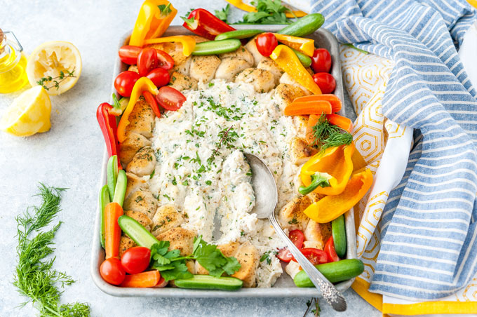 Sheet Pan Ricotta Crab Biscuit Ring Dip with vegetables tucked around and a spoon in the dip