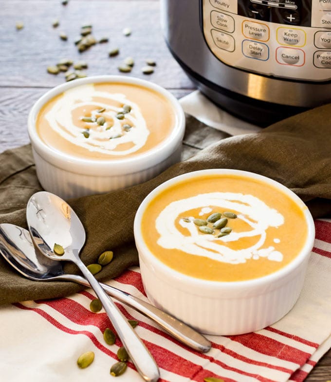 Two bowls of Butternut squash soup with Instant Pot in the background