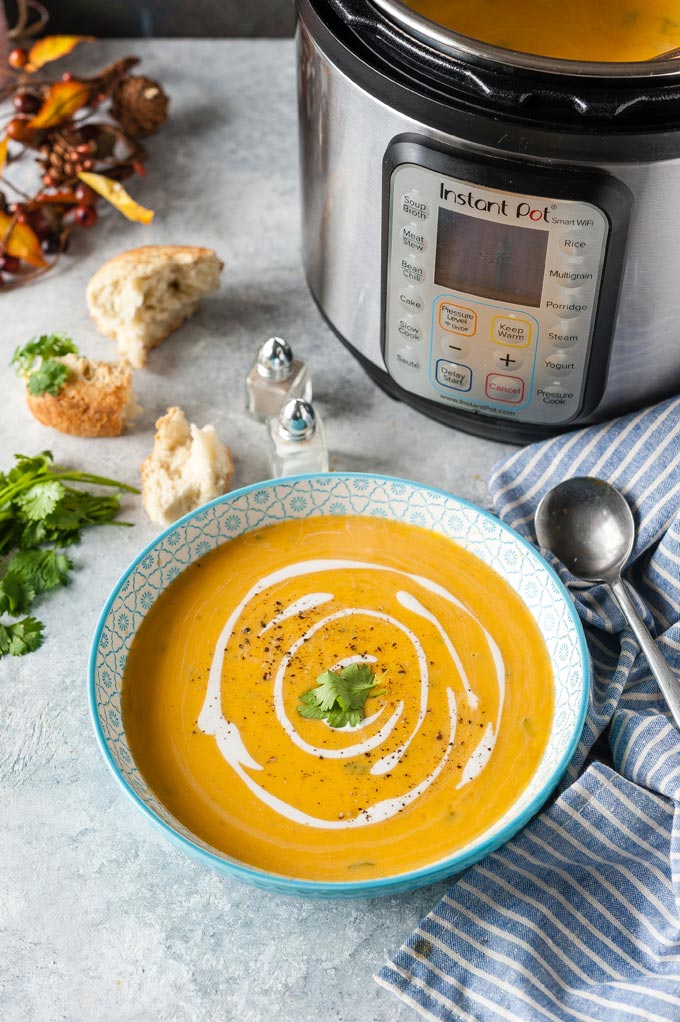 Bowl of Butternut Squash Soup with Instant Pot in the background.