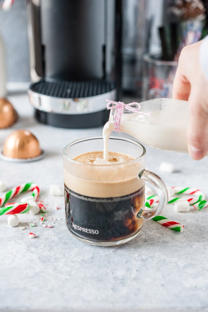 Peppermint creamer pouring into a cup of Nespresso.
