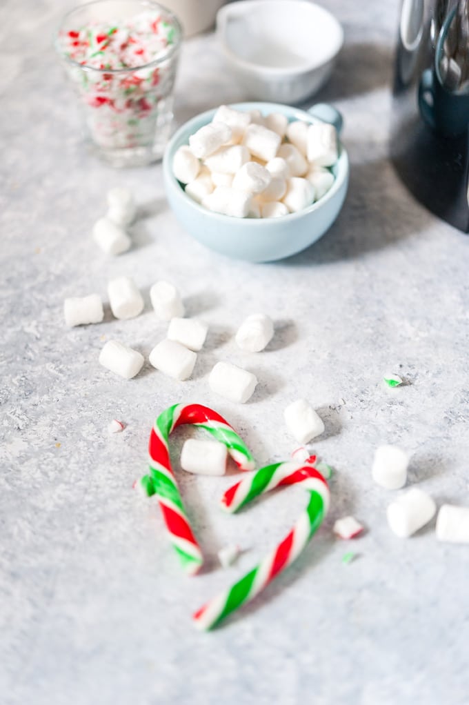 Marshmallows and candy canes on a table.