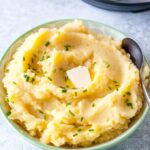 Bowl of mashed potatoes with melting butter on top.