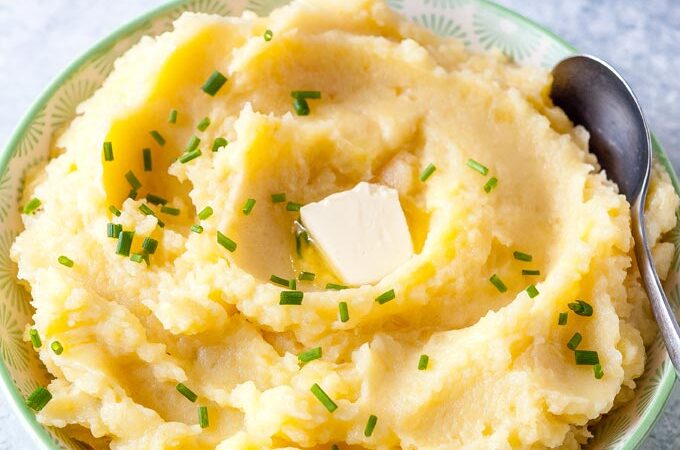 Bowl of mashed potatoes with melting butter on top.
