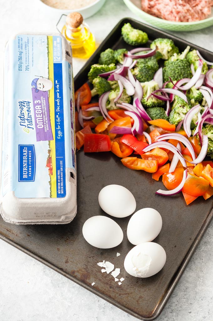 Sheet pan with all the ingredients to make Baked Scotch Eggs with Vegetables