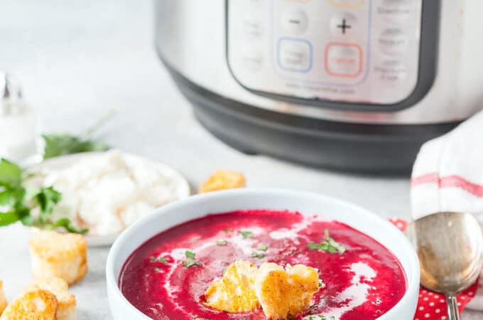 Bowl of beet soup with instant pot in the background.